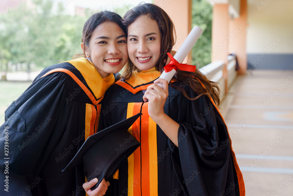 Wall mural female university graduates celebrate happily after completed and received diploma degree certificat