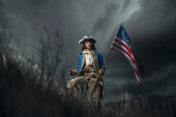 American revolution war soldier with flag of colonies and saber over dramatic landscape. 4 july...