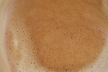 Background of coffee foam texture. Horizontal, cropped shot, top view, close-up. Coffee concept