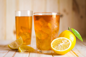 Glasses of ice tea with lemon slices  on wooden background