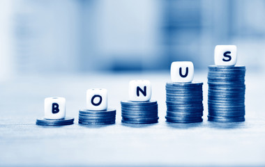 Yearly Bonus concept - words of bonus on stack coins staircase for Encouragement Morale on the table office company