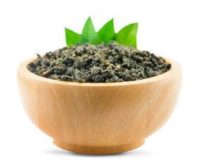 Dry green oolong tea in wooden bowl isolated on white background with clipping path