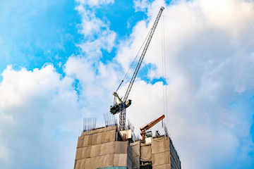 Construction of High-rise Building. Cranes on the Roof of a Skyscraper