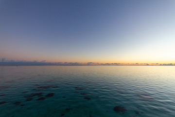 Spectacular view of crystal clear lagoon from overwater bungalow at sunset
