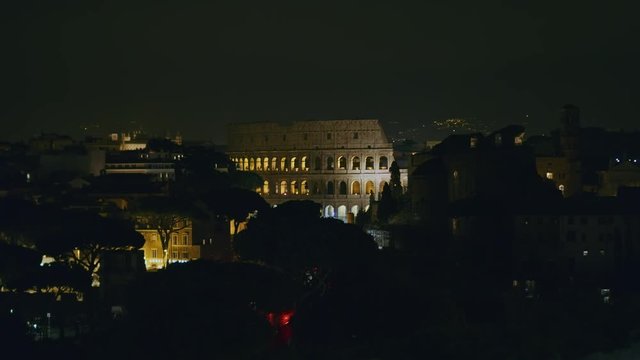 Coliseum "Colosseo, Anfiteatro Flavio" zoom in from Vittoriano Monument at night with low lights. City lights. Shot on Red Monstro 8K. In 4K