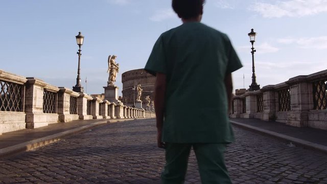 In a semi-abandoned Rome a survivor walks towards "Saint Angel Castle" Castel Sant Angelo and bridge Ponte Sant Angelo over the Tiber river. Birds passing by. Shot on Red Monstro 8K. In 4K