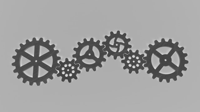 Gears assembled in a puzzle mechanism to work on a gray background. Business concept idea, partnership, cooperation, teamwork.