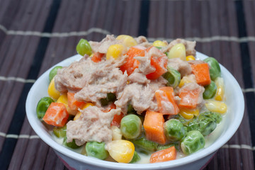 Closeup salad vegetables with tuna in white bowl.