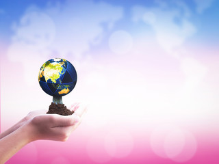 International Day of Cooperatives concept: hands holding Earth  on blurred  nature background