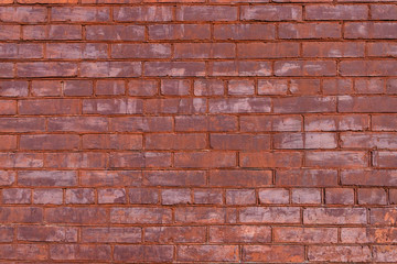 Old red painted brick wall with beautiful rows of speckled bricks.