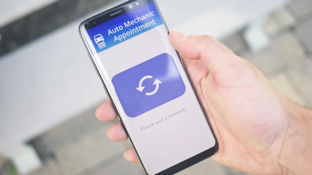 Using an online appointment app to schedule a rendezvous to the car mechanic on a smartphone screen.