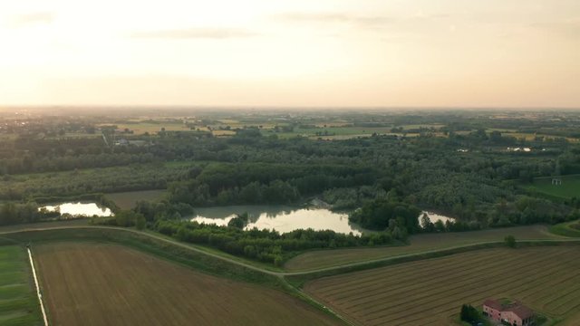 4K Aerial : Cinematic spotlight shot over a natural lake in a typical italian rural landscape