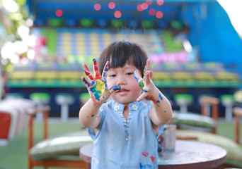 Cute little girl with painted hands, selective focus on hand