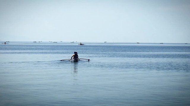 Anglers and small-fry fishermen on tiny rowboats go about finding their daily catch to bring to market at a fishing town in the Visayas region of the Philippines.