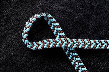 Peyote choker necklace made of seed beads on a dark background close up