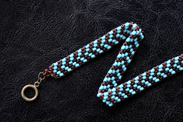 Peyote choker necklace made of seed beads on a dark background close up