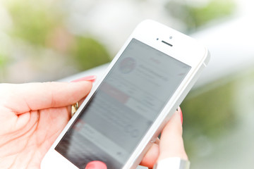 Woman scrolling updates on her social media using her mobile phone.