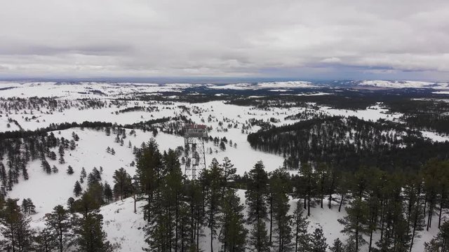 Wilderness Firetower on top of a mountain in the snow Aerial