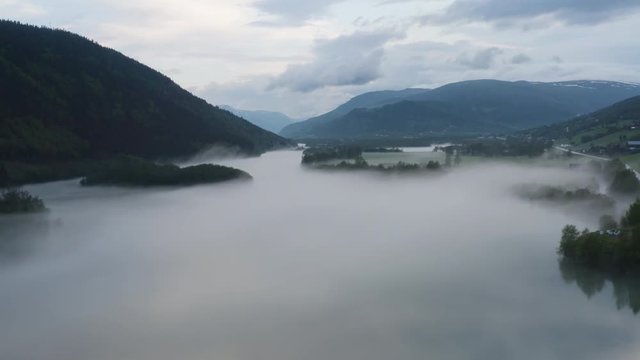 Flight over a foggy river. The mist is hanging low over the landscape creating a dark mystical mood over the whole scene.