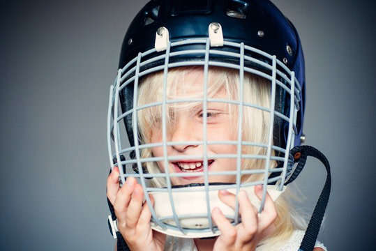 Future sport star. Sport upbringing and career. Girl cute child wear hockey helmet close up. Safety and protection. Protective grid on face. Sport equipment. Hockey or rugby helmet. Sport childhood