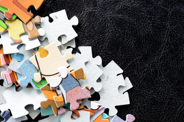 Children's puzzles scattered on a dark surface close-up