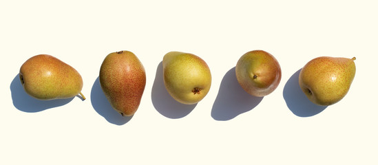 Set of ripe pears with a hard shadow isolated on a light background. Ripe fruit pears.