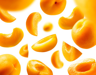 Apricots levitate on a white background. Ripe fruit in flight