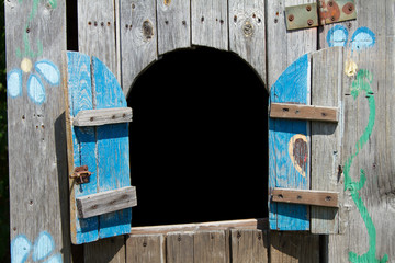 An old wooden playhouse with shutters