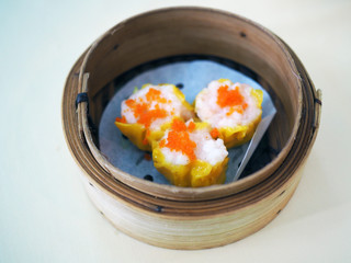 Steamed bamboo basket of hot manti shrimp dumplings , traditional Chinese food. Selective focus.