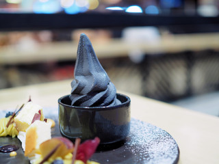 Black charcoal soft serve ice cream, served in black ceramic cup, Traditional Japanese confectionery, Healthy concept. Selective focus.
