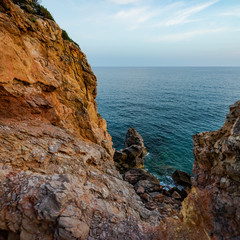 High rocky coast and sea waves of the Mediterranean sea.