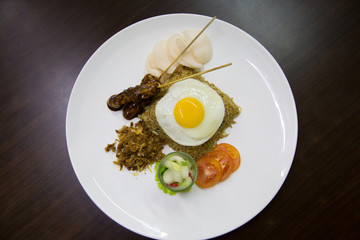 Fried rice with chicken satay, egg and crackers	