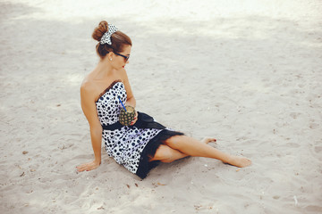 Beautiful girl with a pineapple. Lady in a retro dress. Woman in a sunglasses