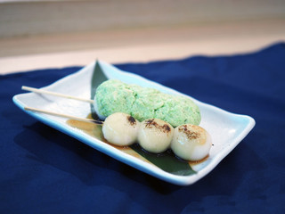 Mitarashi Dungo, round shape made of dough then grilled or burned topped with chopped edamame ....