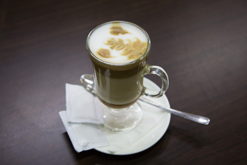 Iced coffee cappuccino latte art with condiment on a table