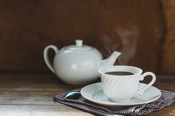 Fototapeta na wymiar white tea set on wooden table, hot drink with steam
