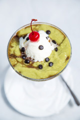 Avocado choco smoothies juice with whipping cream, red cherry, and choco chip.