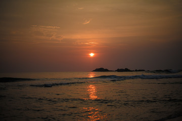 Beautiful orange sun at sunset and a path of light on the waters of the Indian Ocean