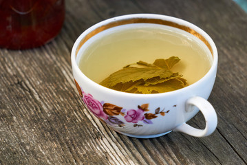 A cup of currant tea on a wooden table