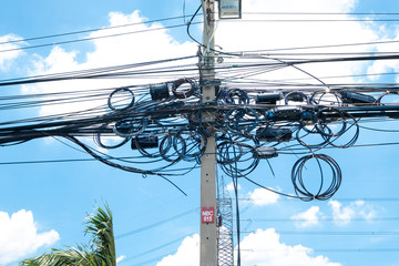 Messy electrical cables in thailand - many lines of cables chaotic set of interwoven, optical fiber...