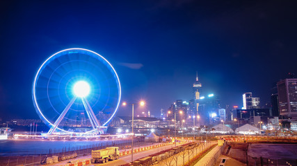 The Observation Wheel in Hong Kong island with a sharp and colourful city skyline at the background.