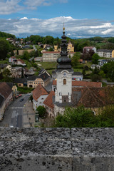 The top of the old cathedral  with the clock at the belfry and blue sky with clouds is popular touristic place in this austrian town