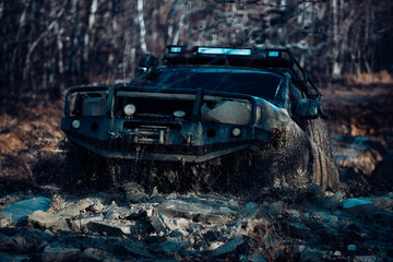 Travel and racing concept for four wheel drive off road vehicle. Detailed view of motion the wheels tires and off-road truck shaft that goes in the snow and mud through the wheels on the forest. © Volodymyr