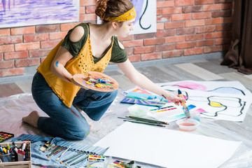 Hobby and recreation. Side view of lefthanded artist painting abstract artworks. Copy space.