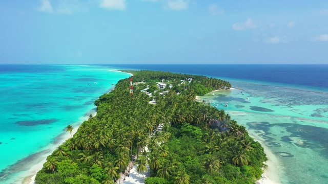 Flight over a tropical island. With a forest of palm trees on it and white beaches. In the turquoise and blue Caribbean Sea. Dolly in