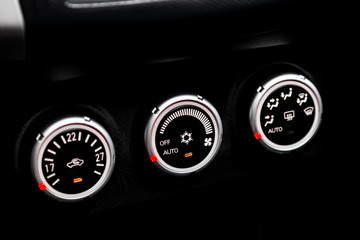 Black detail with the air conditioning button, inside a car. Close up car ventilation system and air conditioning - details and controls of modern car..