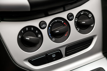 Black detail with the air conditioning button, inside a car. Close up car ventilation system and air conditioning - details and controls of modern car..