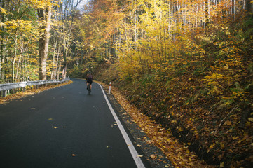 Autumn bike ride with climbing up in the valley covered with golden leaves