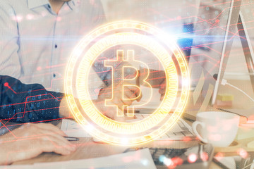 Crypto currency theme hologram with businessman working on computer on background. Concept of...