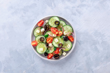 Greek salad, shot from the top. Fresh salad with feta cheese, tomatoes, cucumbers, onions and olives, with a place for text
